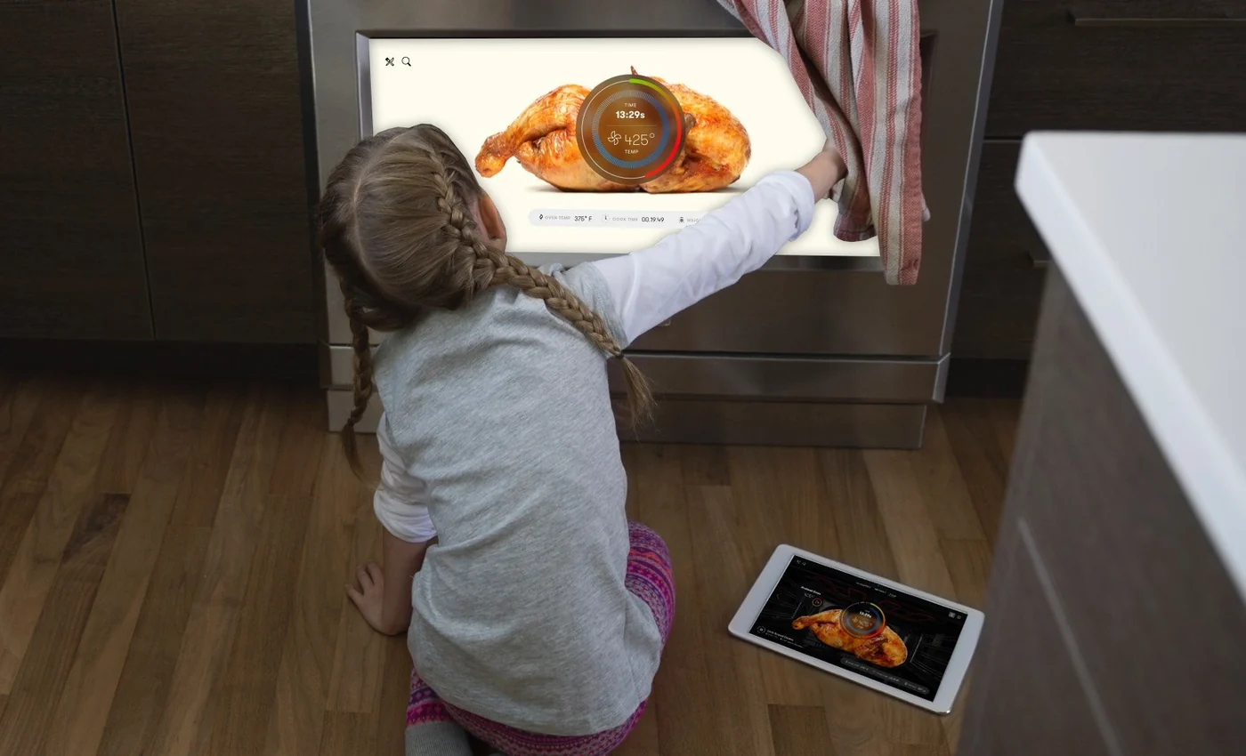 A child watching a roast through the oven window with the Innit ring on the glass, the recipe open on a tablet on the floor